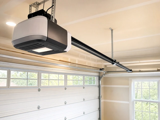 A ceiling-mounted garage door opener is installed above a white sectional garage door with windows, inside a brightly lit garage with beige walls and a large window. A ceiling-mounted garage door opener is installed above a white sectional garage door with windows, inside a brightly lit garage with beige walls and a large window.