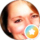 A close-up of a womans smiling face, partially visible, with a circular icon featuring a white star on a blue and orange background in the lower right corner.
